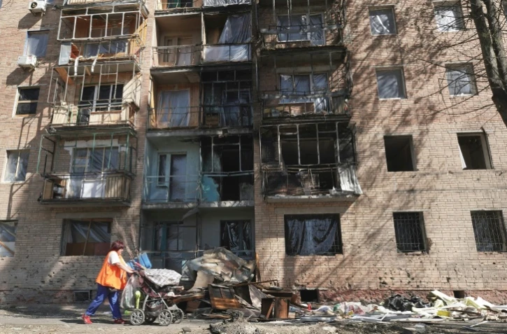 Une habitante passe devant un immeuble touché par des frappes ukrainiennes à Koursk, le 16 août 2024 en Russie