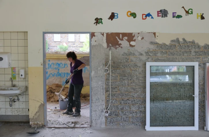 Un volontaire effectue des réparations dans une école élementaire endommagée par les inondations catastrophiques à Dernau, en Allemagne, le 31 aoput 2021