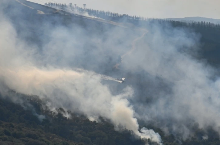 Un avion largue de l'eau sur un incendie à Maceda, au nord-ouest de l'Espagne, le 13 août 2025