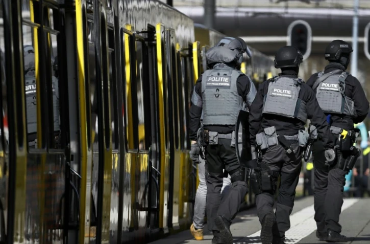 Des policiers marchent le long du tramway où une personne a ouvert le feu à Utrecht, le 18 mars 2019. ANP / AFP (Robin van Lonkhuijsen) 