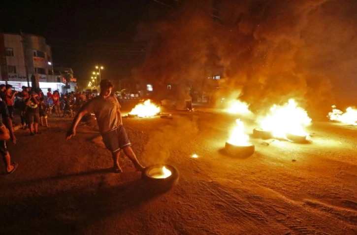 Des protestataires brûlent des pneus lors d'une manifestation à Bassora dans le sud de l'Irak, contre le chômage,le 12 juillet 2018