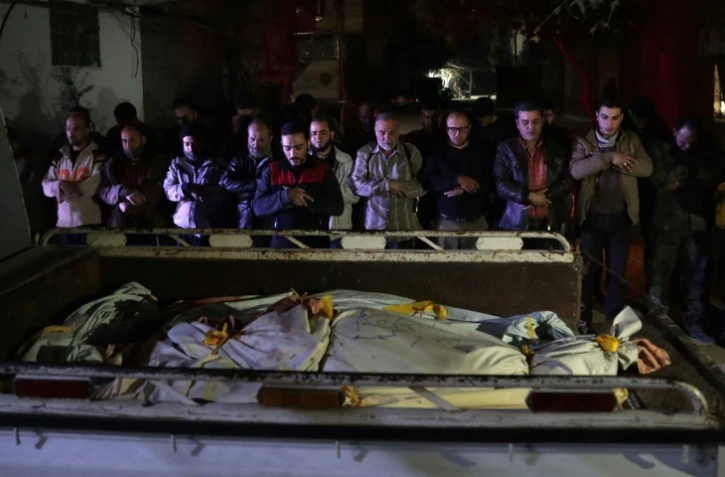 Des Syriens prient devant les corps de victimes d'une frappe aérienne du gouvernement, le 3 avril 2017 dans la ville rebelle de Douma, à l'est de Damas