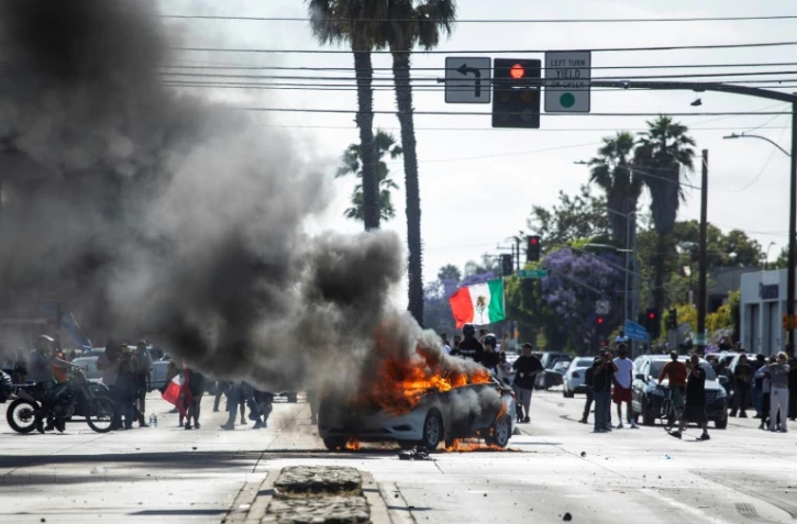 Une voiture en feu lors de manifestations contre les expulsions massives de sans-papiers, le 7 juin 2025 à Los Angeles