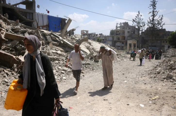 Des Palestiniens fuient leurs maisons dans le quartier de Saftawy à Jabalia, dan le nord de Gaza, le 26 août 2025