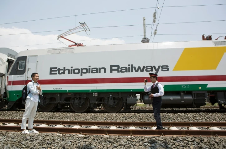 Des employés de la nouvelle ligne ferroviaire reliant Addis Abeba à Djibouti, prennent une photo devant une motrice, à Addis Abeba, le 24 septembre 2016