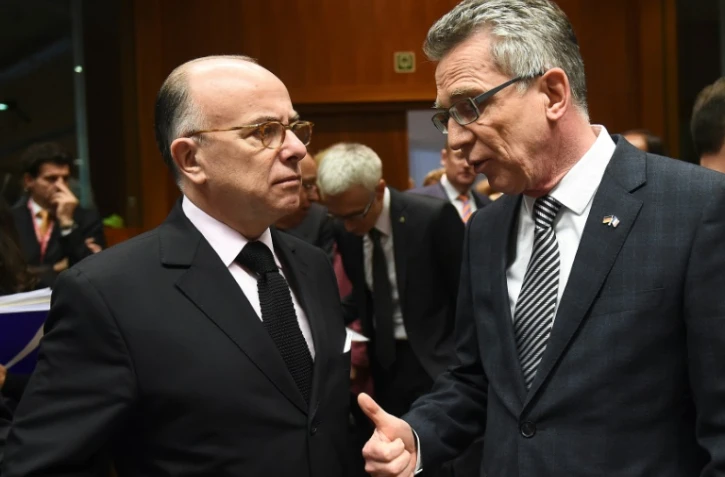 Les ministres de l'Intérieur français Bernard Cazeneuve (g) et allemand Thomas de Maizière  au Conseil européen à Bruxelles, le 20 novembre 2015