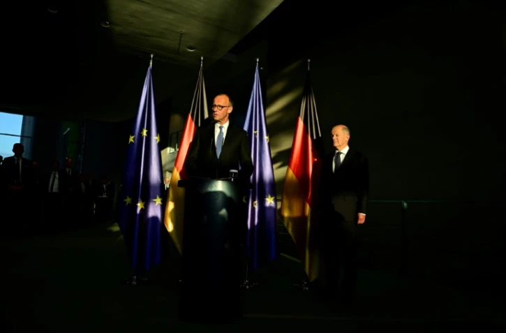 Le chancelier allemand nouvellement élu Friedrich Merz s'exprime tandis que son prédécesseur Olaf Scholz l'écoute lors d'une cérémonie de passation de pouvoirs à la Chancellerie à Berlin, le 6 mai 2025