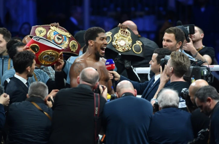 Le boxeur britannique Anthony Joshua (c) exulte après son combat victorieux face à l'Américain d'origine mexicaine Andy Ruiz, le 7 décembre 2019 à Diriya 
