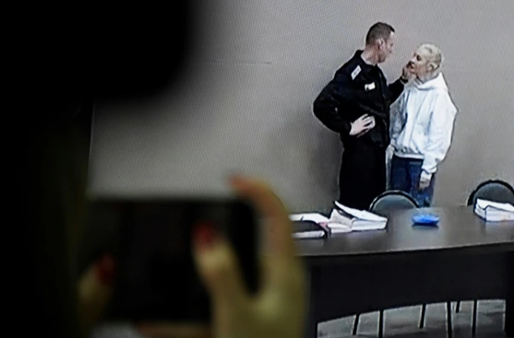 Un écran dans une salle de presse diffuse des images d'Alexeï Navalny parlant à sa femme Ioulia avant son procès, le 15 février 2022 à Pokrov, en Russie