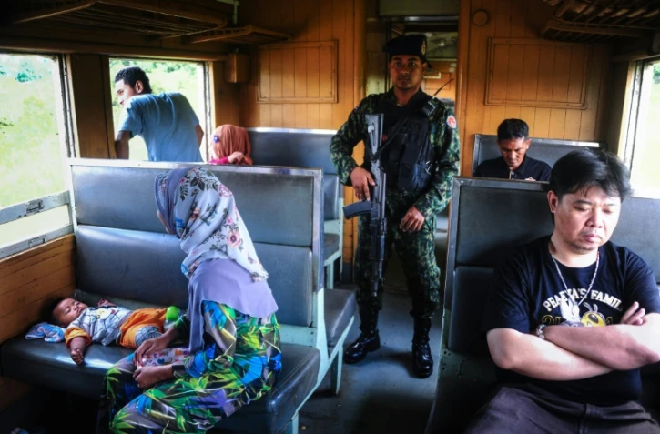 Un soldat au milieu des passagers du train de 12H33, le 21 novembre 2016 à Narathiwat dans l'extrême sud de la Thaïlande