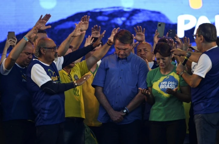Le président brésilien Jair Bolsonaro et son épouse Michelle Bolsonaro prient avec le pasteur Silas Malafaia et d'autres membres  évangéliques, le 13 août 2022 à Rio de Janeiro