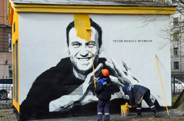 Un ouvrier fait disparaître le visage de l'opposant russe Alexeï Navalny sur un mur de Saint-Pétersbourg, le 28 avril 2021