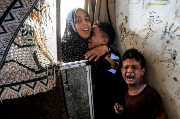 Des enfants en pleurs après une frappe israélienne, à l'école al-Jaouni de Nousseirat, gérée par l'ONU et abritant des déplacés dans le centre de Gaza, le 6 juillet 2024