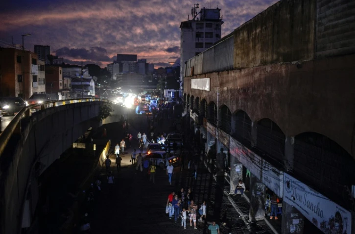 Des habitants dans une rue de Petare, un quartier de Caracas, pendant une panne d'électricité, le 22 juillet 2019 au Venezuela