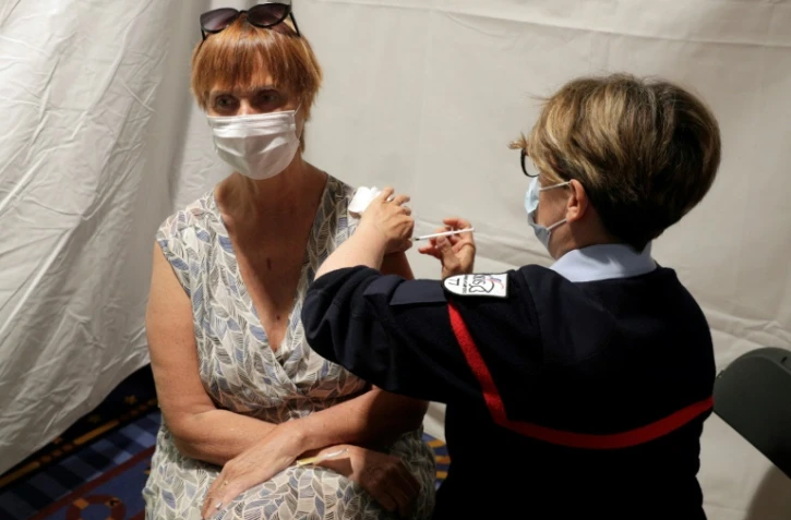 Une femme reçoit une dose du vaccin anti-Covid Pfizer/BioNTech dans le centre de vaccination provisoire mis en place dans le parc d'attractions de Disneyland Paris à Coupvray (Seine-et-Marne), le 24 avril 2021