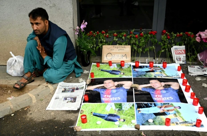Un Afghan assis à côté de portraits de Quayyeem Ahmadzai, tué par balle dimanche dans une altercation, le 17 août 2022 à Colmar