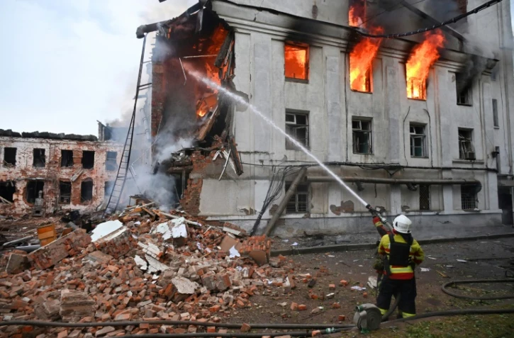 Un pompier lutte contre un incendie dans un bâtiment après une série d'attaques russes contre la ville de Kharkiv, dans l'est de l'Ukraine, le 7 juin 2025