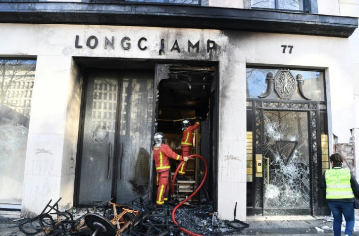 Les pompiers interviennent sur un feu à la boutique Longchamp, pendant la manifestation des "gilets jaunes", sur les Champs-Elysées  à Paris, le 16 mars 2019