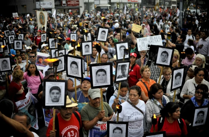 Les portraits d'étudiants disparus brandis par leurs proches lors d'une marche le 26 avril 2016 à Mexico