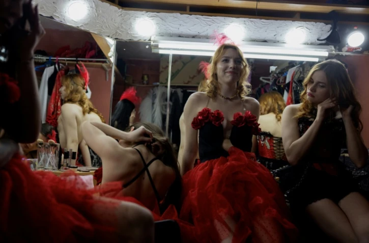 Lisa (c) et d'autres danseuses se préparent pour une représentation dans une loge du club de strip-tease "Flash Dancers", le 15 mai 2025 à Kharkiv, en Ukraine