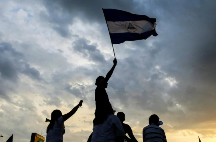 Des manifestants brandissent un drapeau du Nicaragua lors d'une manifestation contre le gouvernement, le 15 mai 2018 Ă Managua