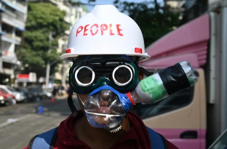 Un manifestant contre le coup d'Etat en Birmanie, muni d'un équipement de fortune pour se protéger des gaz lacrymogène, à Rangoun le 2 mars 2021