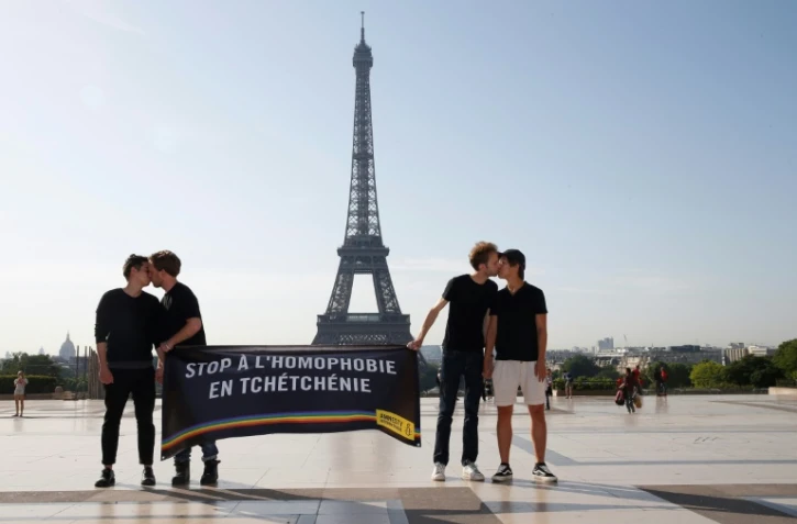Des militants d'Amnesty s'embrassent devant la tour Eiffel à Paris dans le cadre d'une manifestation contre l'homophobie en Tchétchénie, le 29 mai 2017
