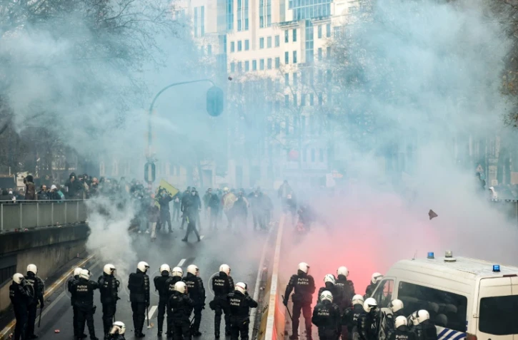 Des manifestants face aux forces de l'ordre pendant une manifestation contre les nouvelles mesures contre le Covid-19, à Bruxelles le 21 novembre 2021