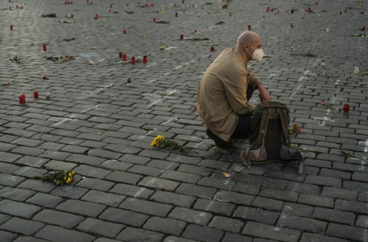 Un homme se recueille en mémoire des victimes du Covid le 29 mars 2021 à Prague