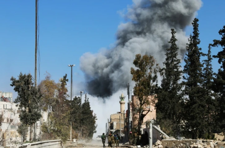 Des combattants rebelles pro-turcs dans une rue de Al-Bab, après un raid aérien sur une position de l'EI, le 21 février 2017 en Syrie