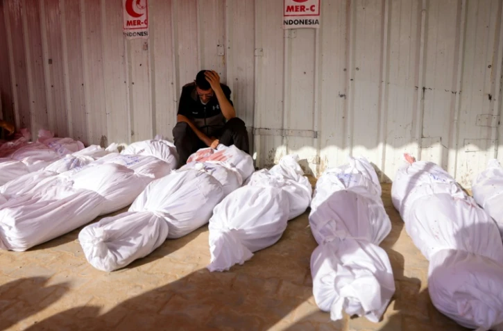 Un Palestinien pleure devant des corps de victimes des frappes israéliennes sur Jabalia, à l'hôpital indonésien de Beit Lahia, dans le nord de la bande de Gaza, le 14 mai 2025