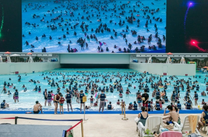 Des gens se baignent dans un mer artificielle dans le "New Century Global Center" de Chengdu, la capitale du Sichuan, le 25 juillet 2016