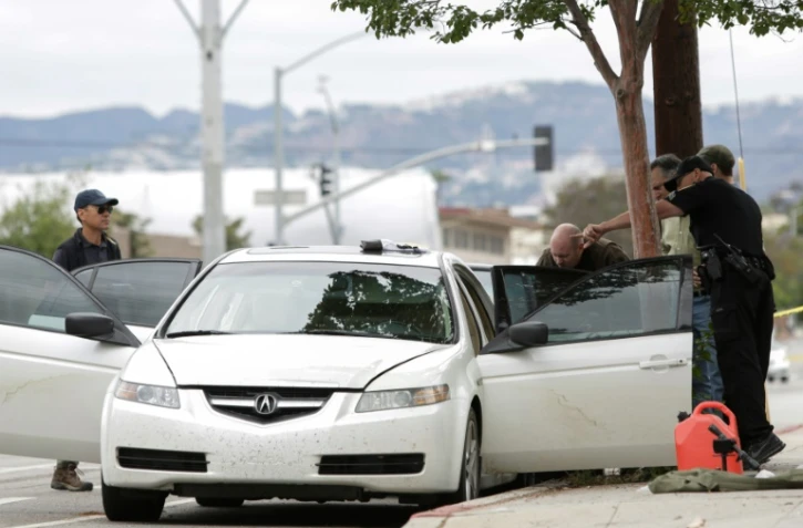 Des policiers inspectent un véhicule qui pourrait appartenir à un homme arrêté transportant un arsenal d'armes et d'explosifs, à Santa Monica, le 12 juin 2016 
