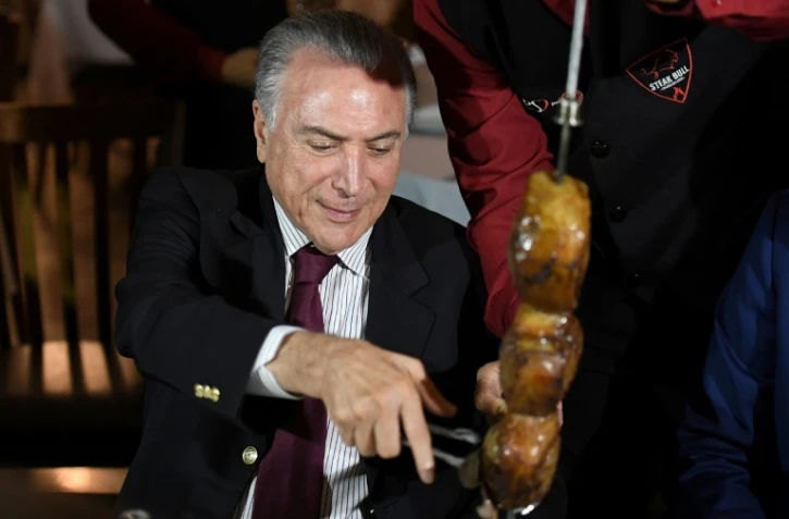 Le président brésilien Michel Temer lors d'un barbecue auquel des ambassadeurs étrangers étaient invités après une réunion d'urgence sur le démantèlement d'un réseau de commercialisation de viande avariée au Brésil, le 19 mars 2017 à Brasilia