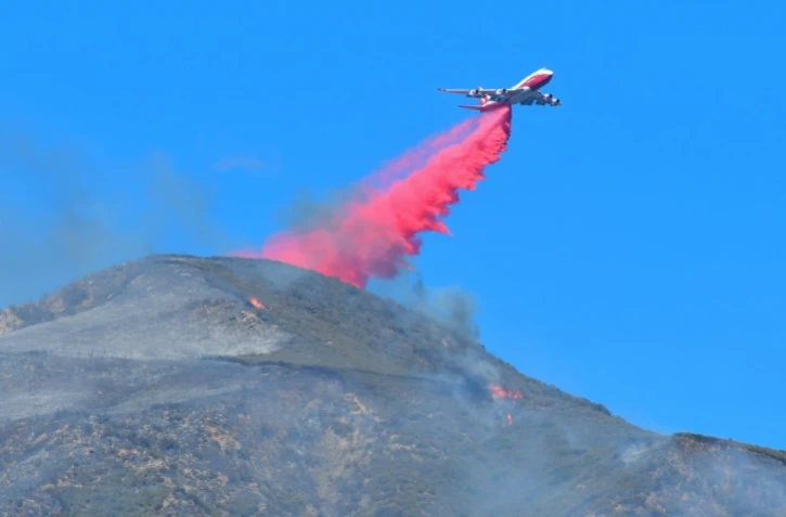 Un avion largue du produit retardant au sommet d'une montagne du comté de Ventura, Californie, le 8 décembre 2017
