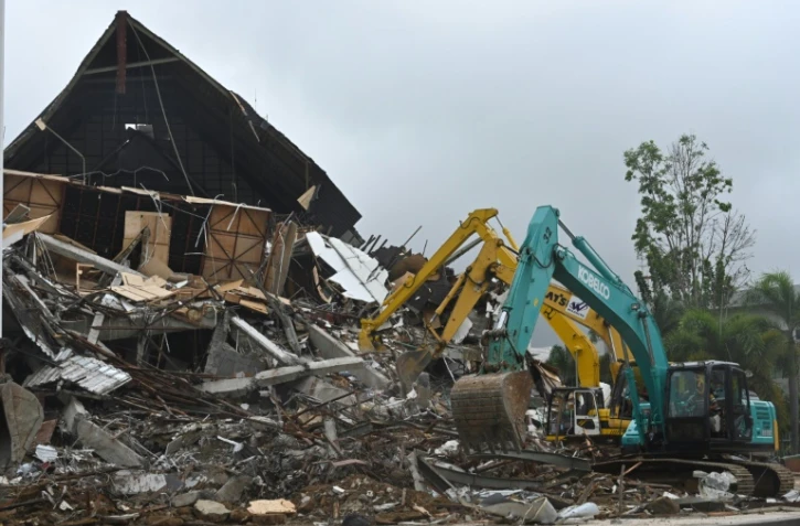 Des pelles mécaniques pour déblayer les décombres à Mamuju sur l'ïle de Célèbes en Indonésie,le 17 janvier 2021
