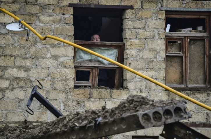 Un vieil homme regarde par une fenêtre endommagée par une explosion à Stepanakert au Nagorny Karabakh le 6 octobre 2020