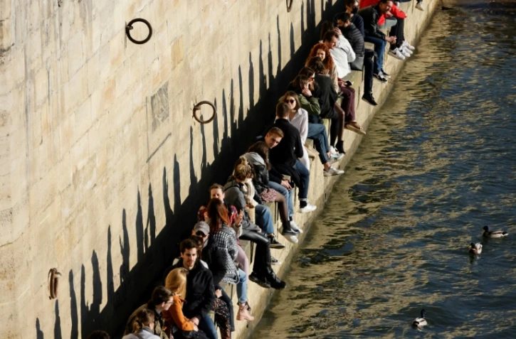 Des personnes se rassemblent le long de la Seine pour profiter d'un après-midi ensoleillé, à Paris, le 28 février 2021