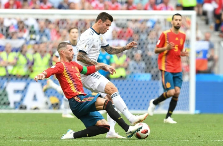 Le défenseur espagnol Sergio Ramos (g) à la lutte avec l'attaquant russe Fedor Smolov en 8e de finale du Mondial, le 1er juil 2018 à Moscou   