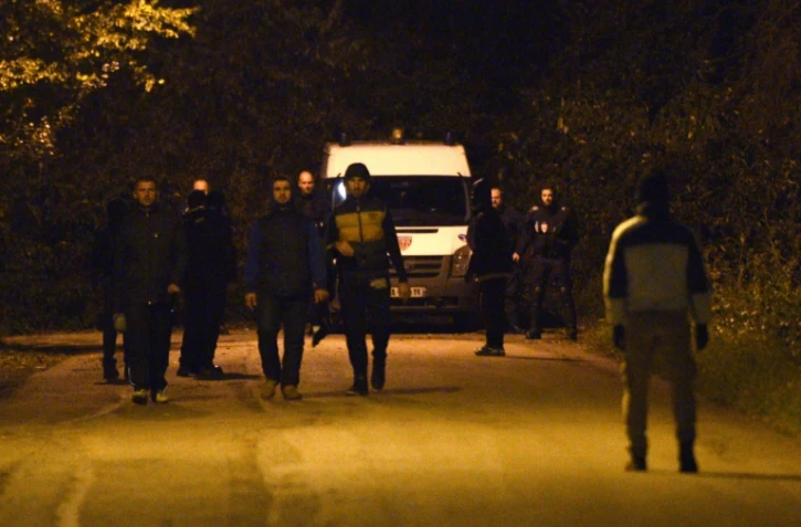 Des migrants marchent devant un car de CRS à Calais, le 10 novembre 2015 