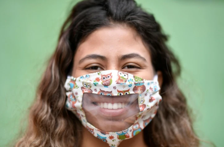 Une femme porte un masque transparent confectionné par des couturières d'une favela de Belo Horizonte, au Brésil, le 15 mai 2020
