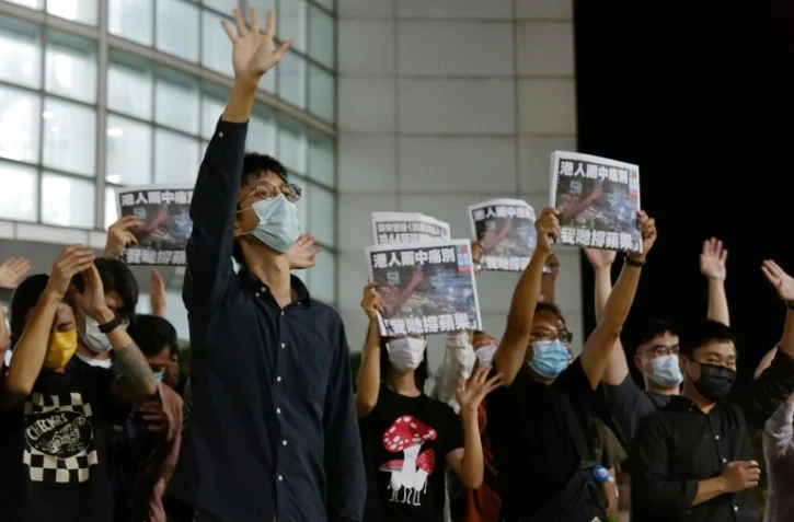 Des journalistes de l'Apple Daily tiennent des exemplaires du dernier numéro du quotidien pro-démocratie, le 24 juin 2021 à Hong Kong