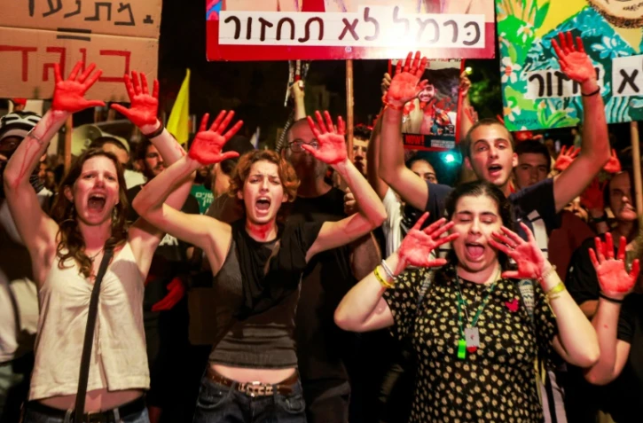 Des manifestantes israéliennes aux mains peintes en rouge, couleur du sang, scandent des slogans contre le gouvernement et pour la libération des otages retenus à Gaza, près de la résidence du Premier ministre Benjamin Netanyahu à Jérusalem, le 2 septembre 2024