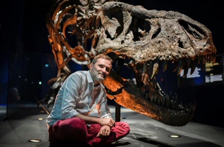 Le paléontologue français Ronan Allain pose devant le squelette d'un Tyrannosaurus Rex, le 1er juin 2018 au Muséum d'histoire naturelle de Paris, avant l'exposition "un T.Rex à Paris" du 6 juin au 2 septembre