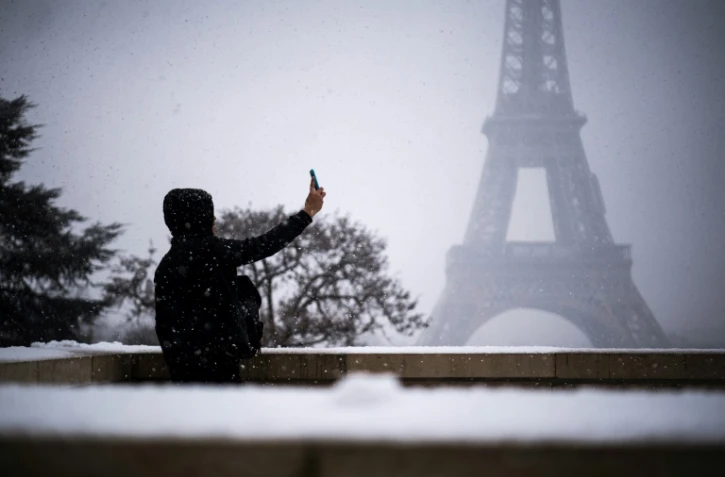 Une personne prend un selfie sous la neige devant la Tour Eiffel, le 5 février 2018 à Paris
