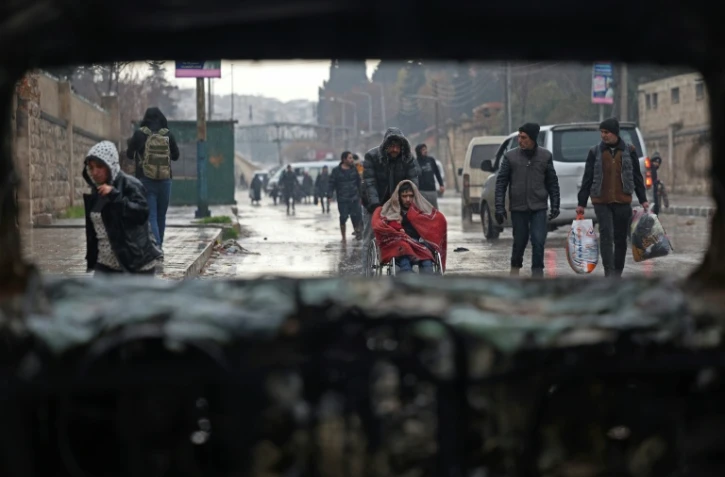 Des habitants du quartier kurde de  Cheikh Maqsoud à Alep, dans le nord de la Syrie, évacuent après un nouvel avertissement de l'armée syrienne, le 9 janvier 2026