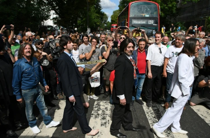 Des sosies traversentle passage piétons d'Abbey Road, rendu célèbre par les Beatles 50 ans plus tôt, le 8 août 2019 à Londres