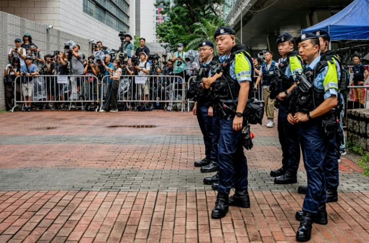 Des policiers près de l'espace réservé aux médias devant les tribunaux de première instance de West Kowloon, avant le verdict du procès pour atteinte à la sécurité nationale de deux militants prodémocratie de la mémoire de Tiananmen, à Hong Kong, le 21 août 2026