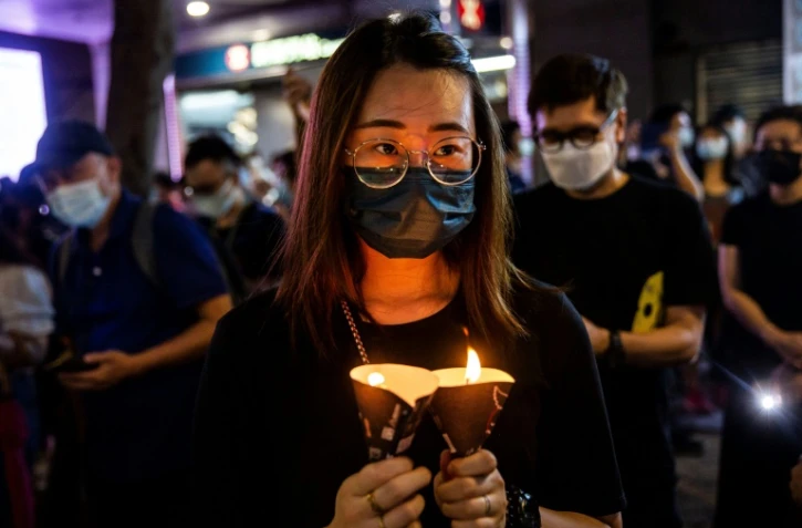 Une femme tient une bougie lors de la veillée en souvenir de Tiananmen le 4 juin 2021 à Hong Kong