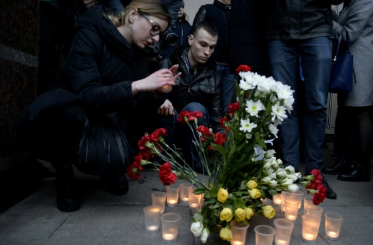 Des personnes déposent des fleurs et des bougies en mémoire aux victimes de l'attentat du métro, devant la station Sennaya, le 3 avril 2017 à Saint-Pétersbourg